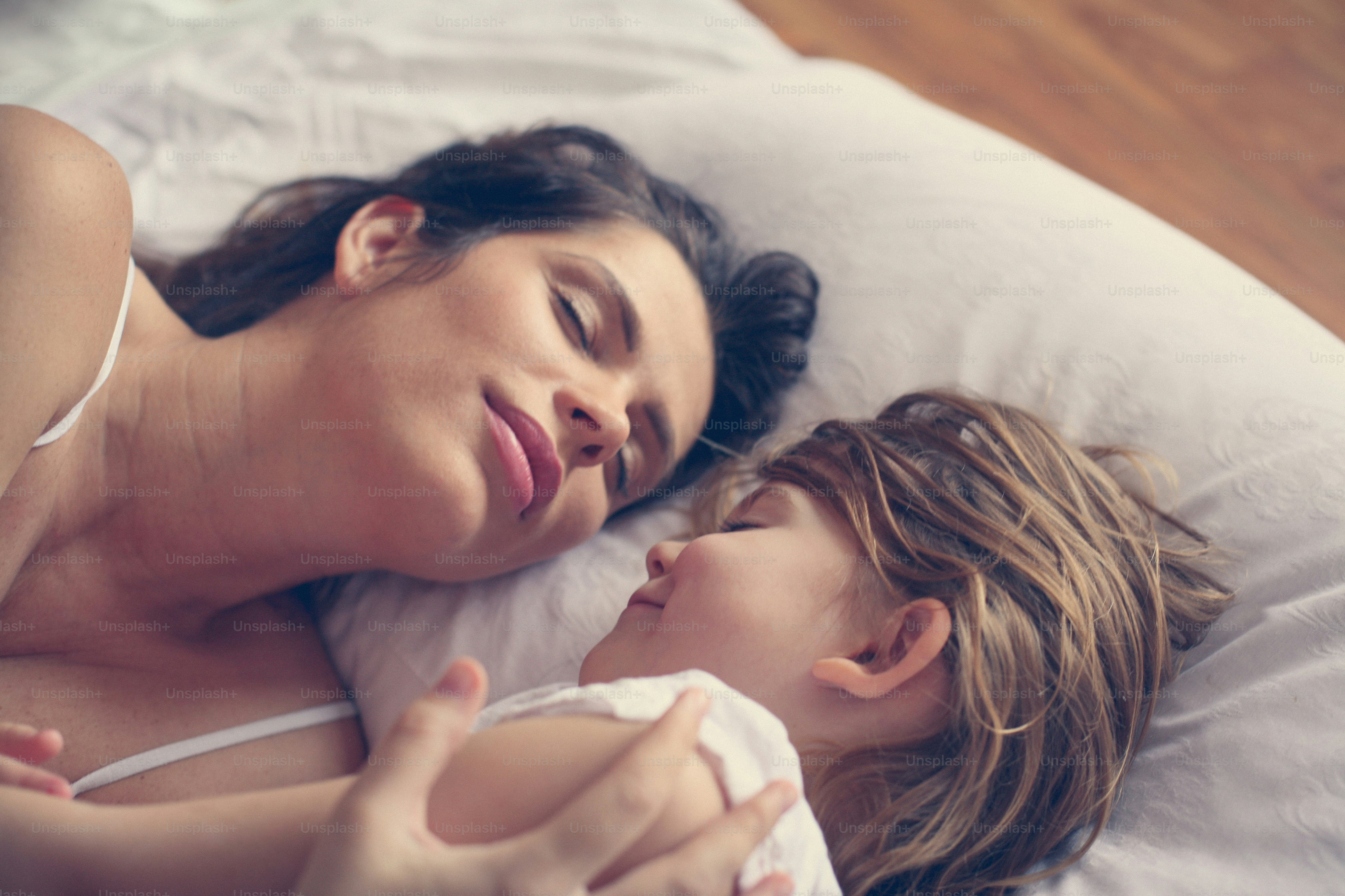 Mother and daughter sleeping in the bed.