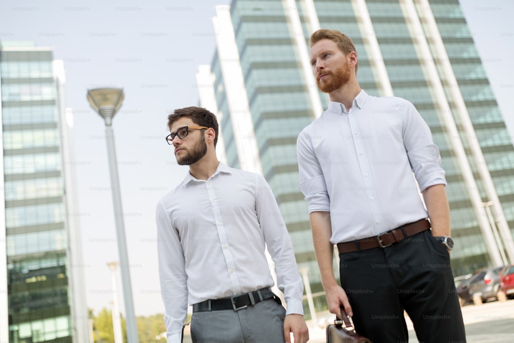 Handsome business colleagues in shirt walking outdoors