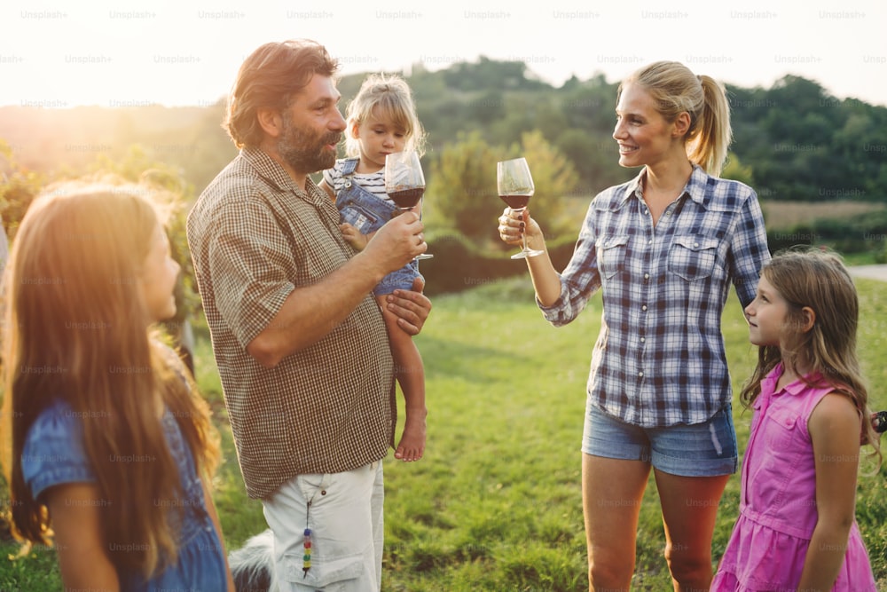 Familia de viticultores felices juntos en el viñedo antes de la vendimia