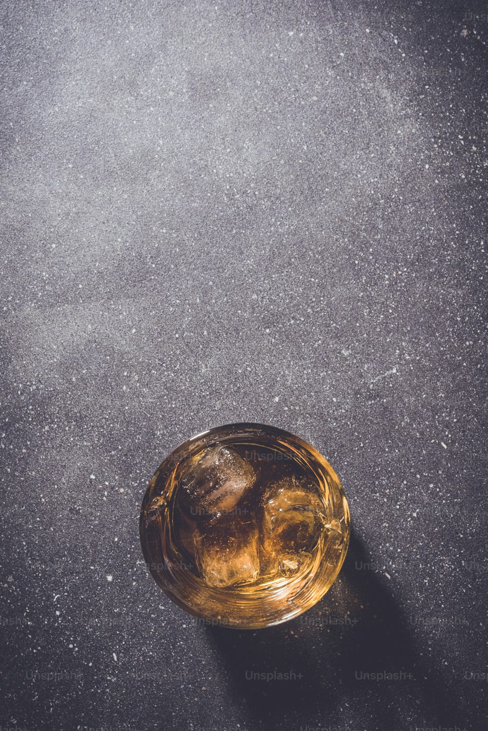 灰色の石の背景にウイスキーのグラス。クローズアップ