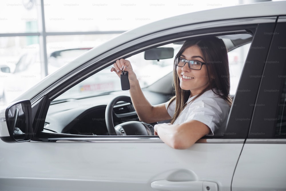 Jeune femme heureuse près de la voiture avec les clés à la main - concept d’achat de voiture