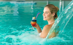 Beautiful woman enjoying jet of water in spa  resort