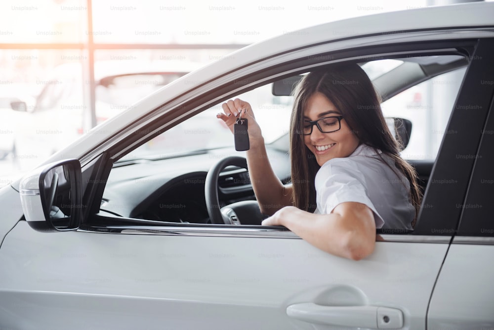 Junge glückliche Frau in der Nähe des Autos mit Schlüsseln in der Hand - Konzept des Autokaufs
