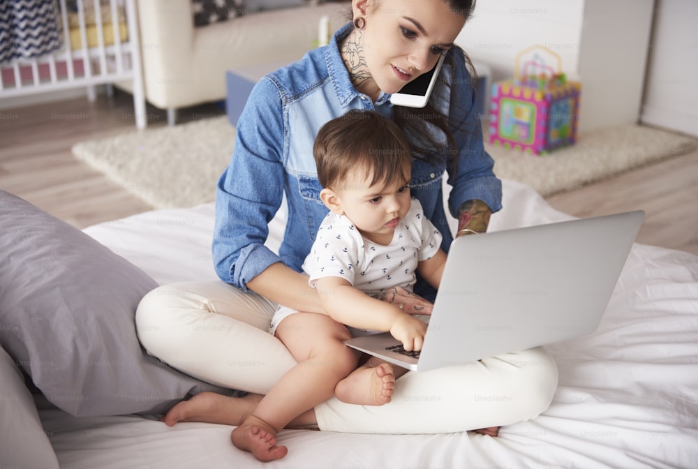 Young mother working from home with son