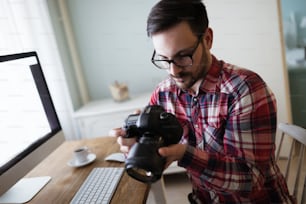Photographe retoucheur travaillant sur des photos et retouchant sur un ordinateur de bureau