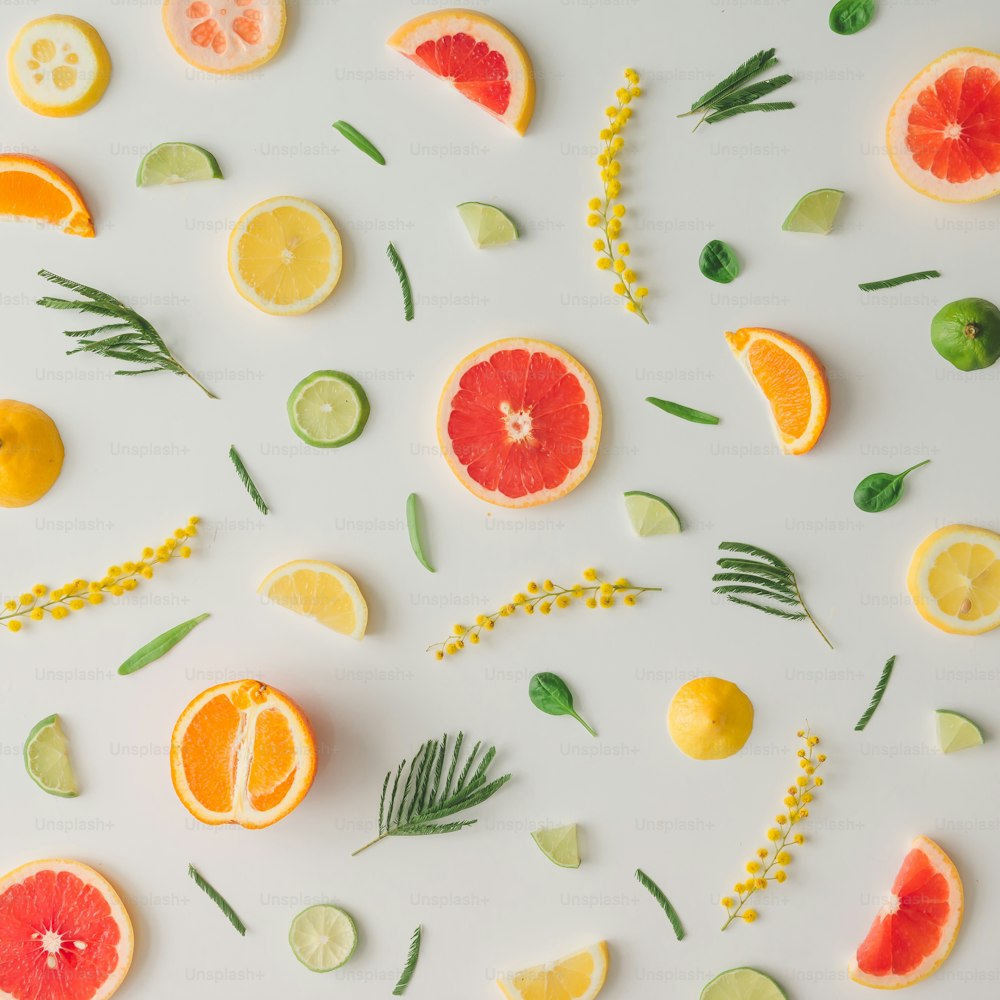 Colorful food pattern made of lemon, orange, grapefruit and flowers. Flat lay.