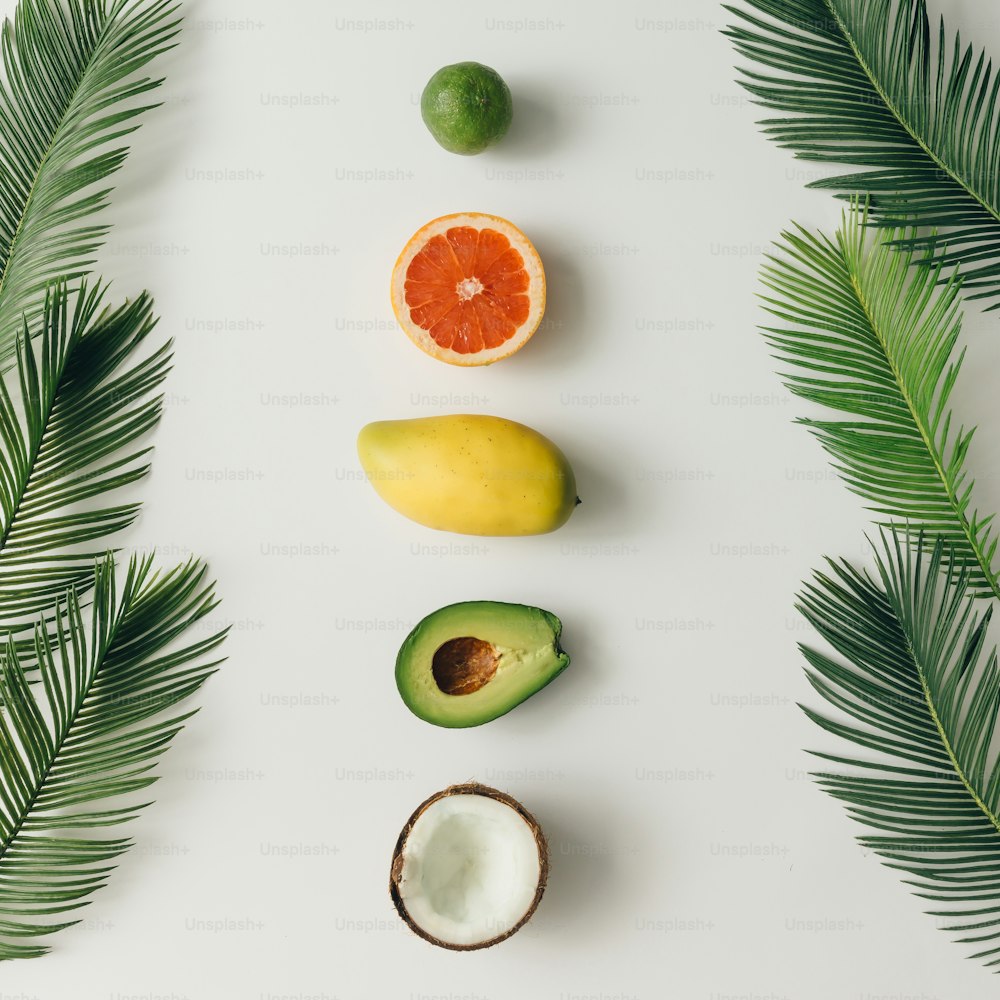 Creative layout made of summer tropical fruits and leaves. Flat lay. Food concept.