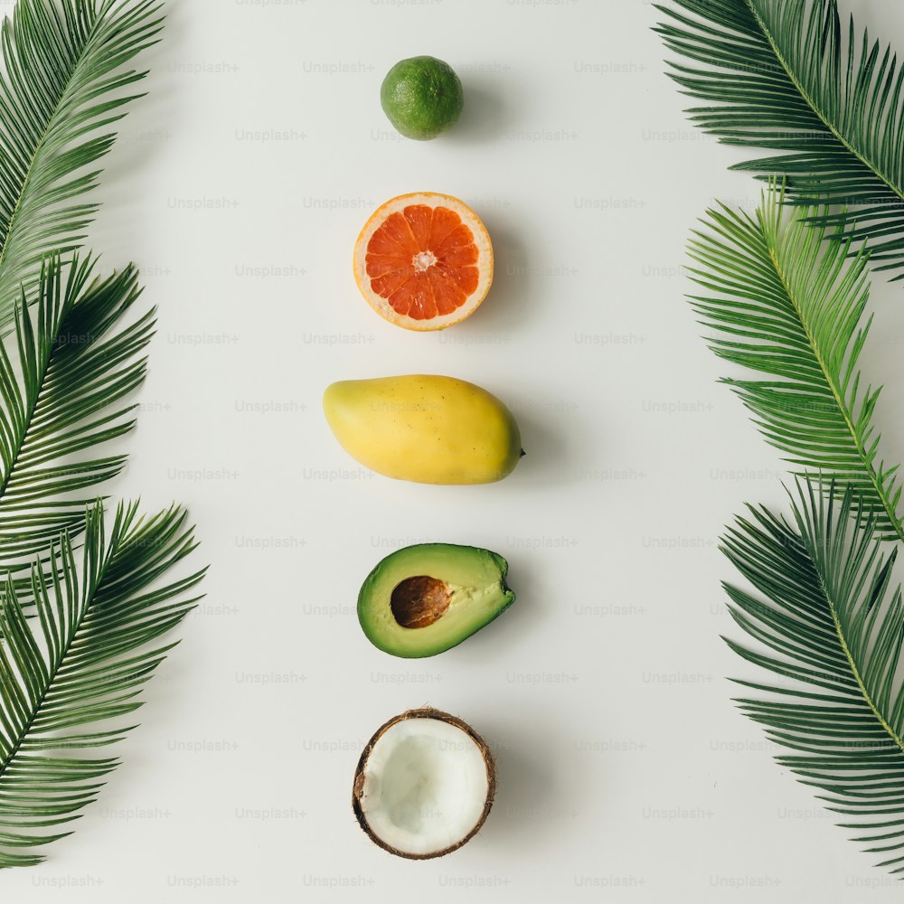 Creative layout made of summer tropical fruits and leaves. Flat lay. Food concept.