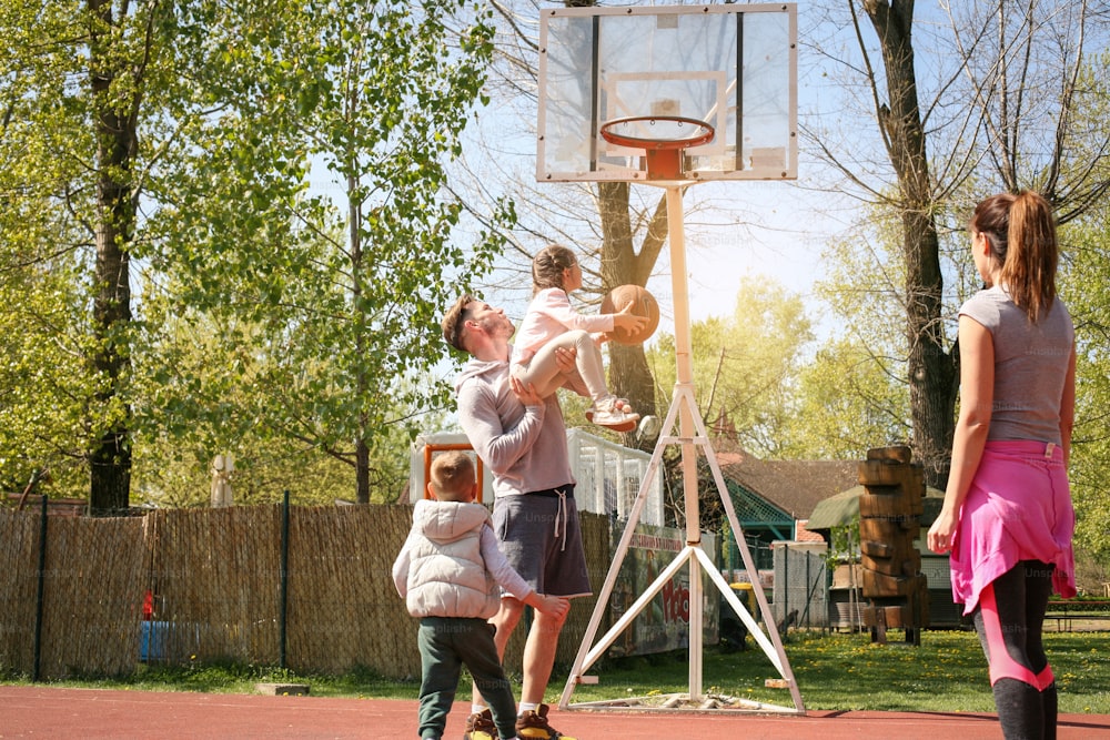Caucasian family playing basketball together