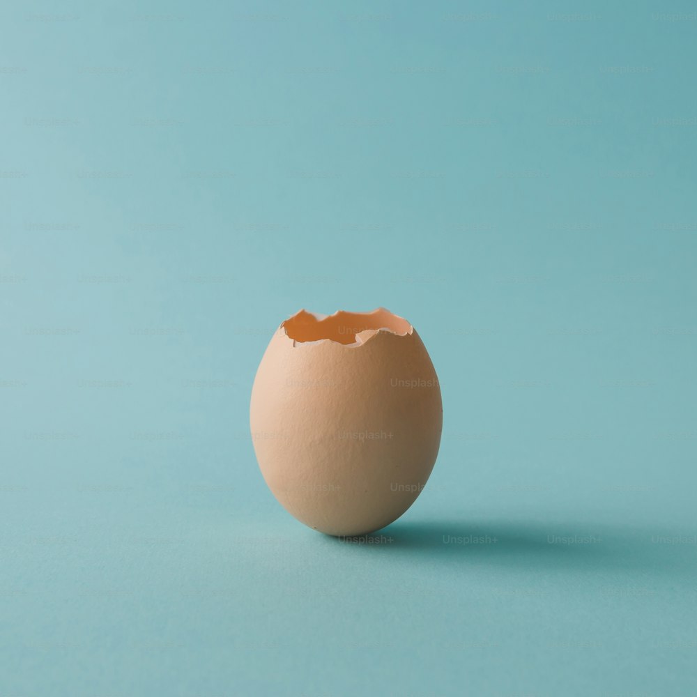 Coquille d’œuf sur fond bleu vif. Concept minimal.