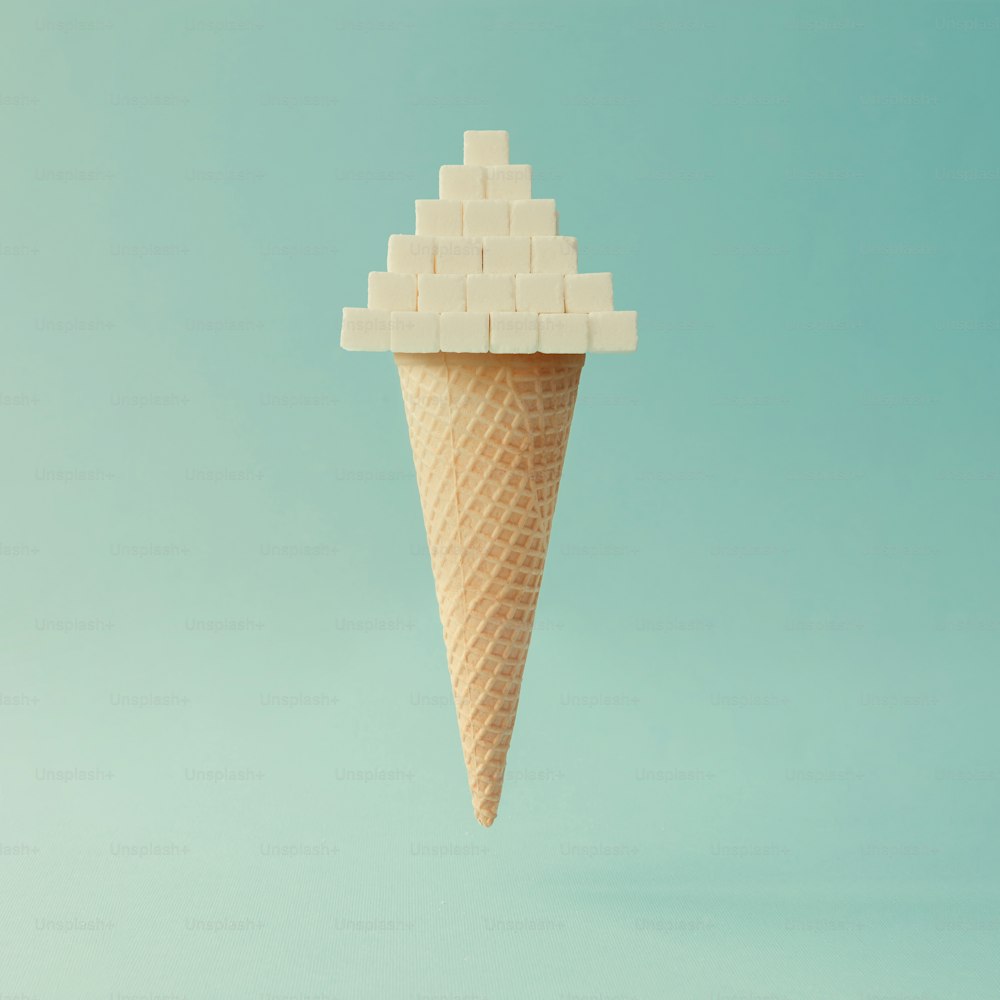 Ice cream cone with sugar cubes on bright blue background. Minimal food concept.