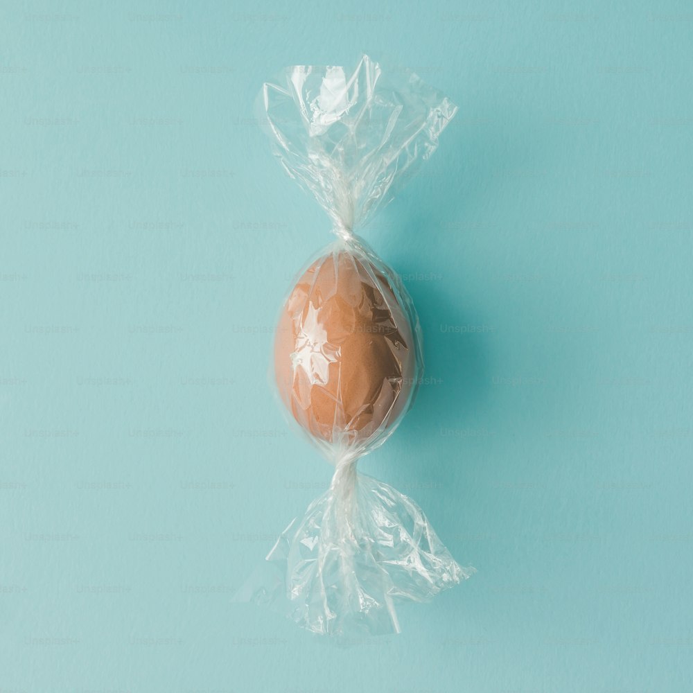 Egg wrapped like candy on bright blue background. minimal Easter concept.
