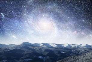 Fantastica pioggia di meteoriti invernali e le montagne innevate. Scena drammatica e pittoresca. Per gentile concessione della NASA. Carpazi, Ucraina, Europa.