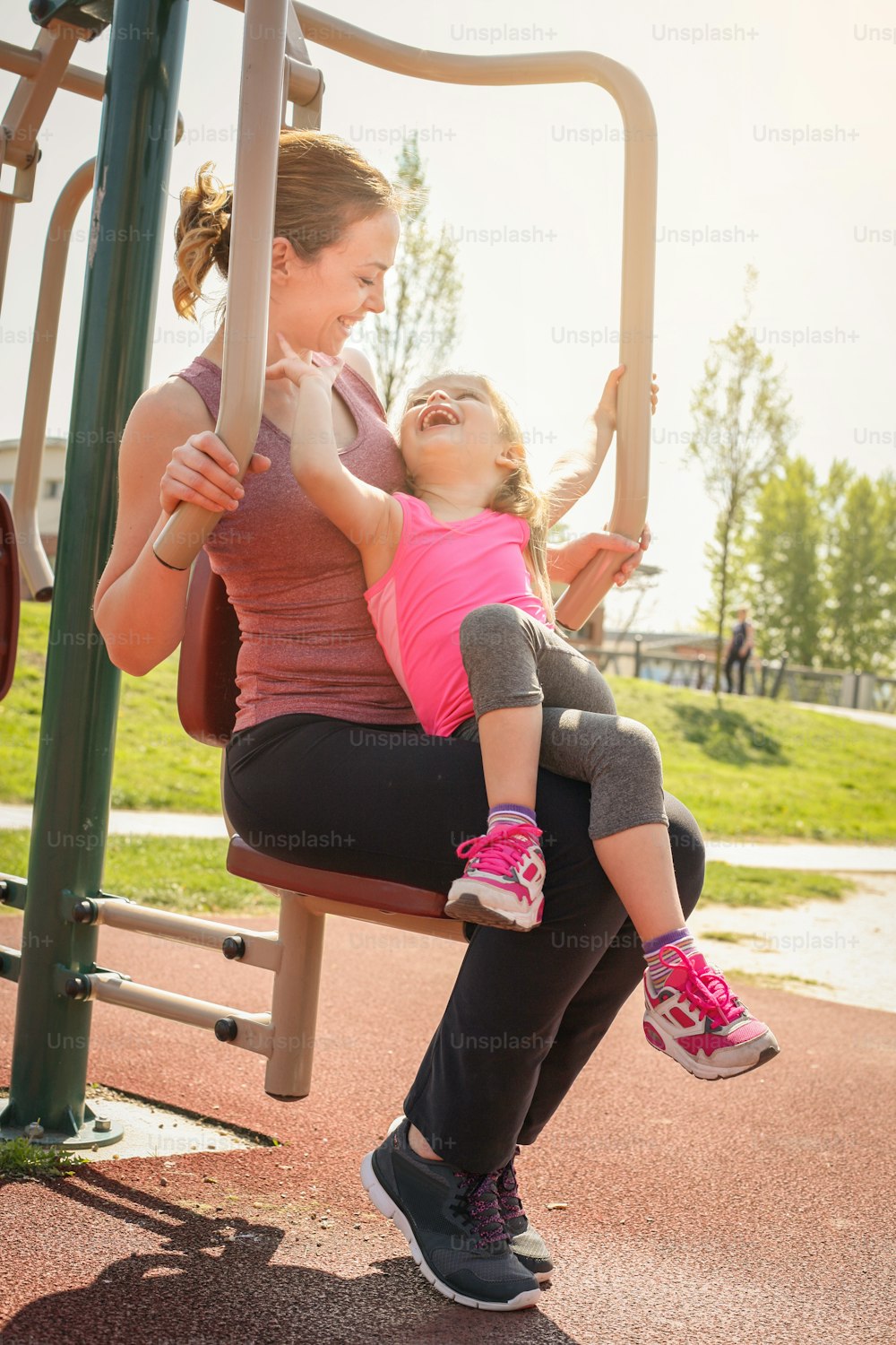 Mother and daughter outdoor exercise. Mother and daughter in the outdoor gym.