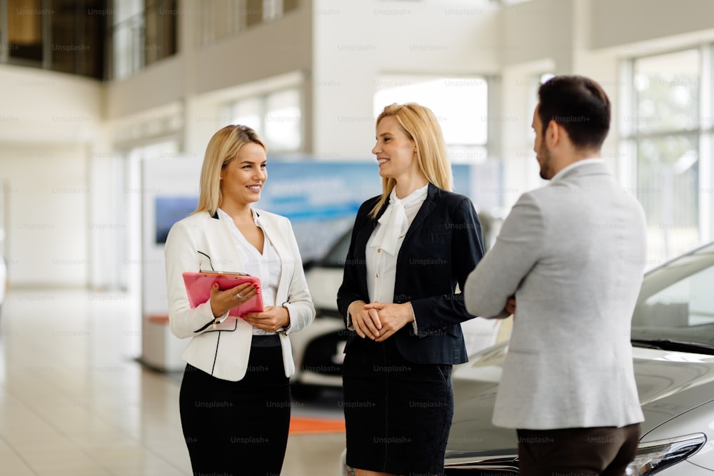 Professional salesperson selling cars at dealership to buyer