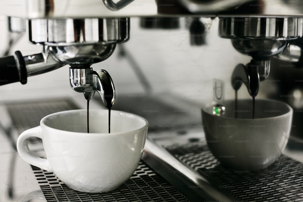 Moderna cafetera de cápsulas con goteo de espresso, taza, vainas y granos  en mesa grunge gris Fotografía de stock - Alamy