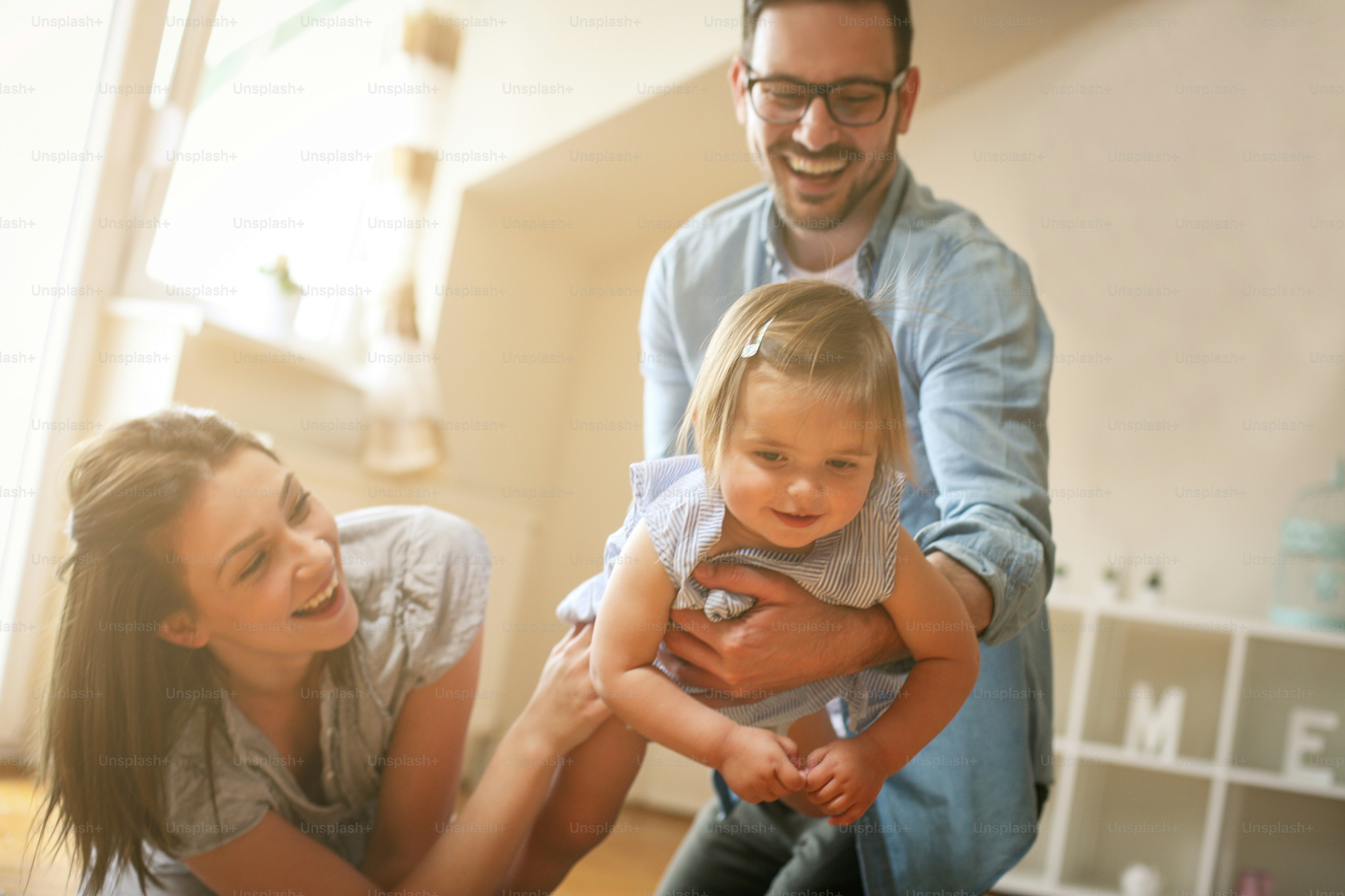 Familia feliz sentada en el suelo con su pequeño bebé. Familia pasando ...
