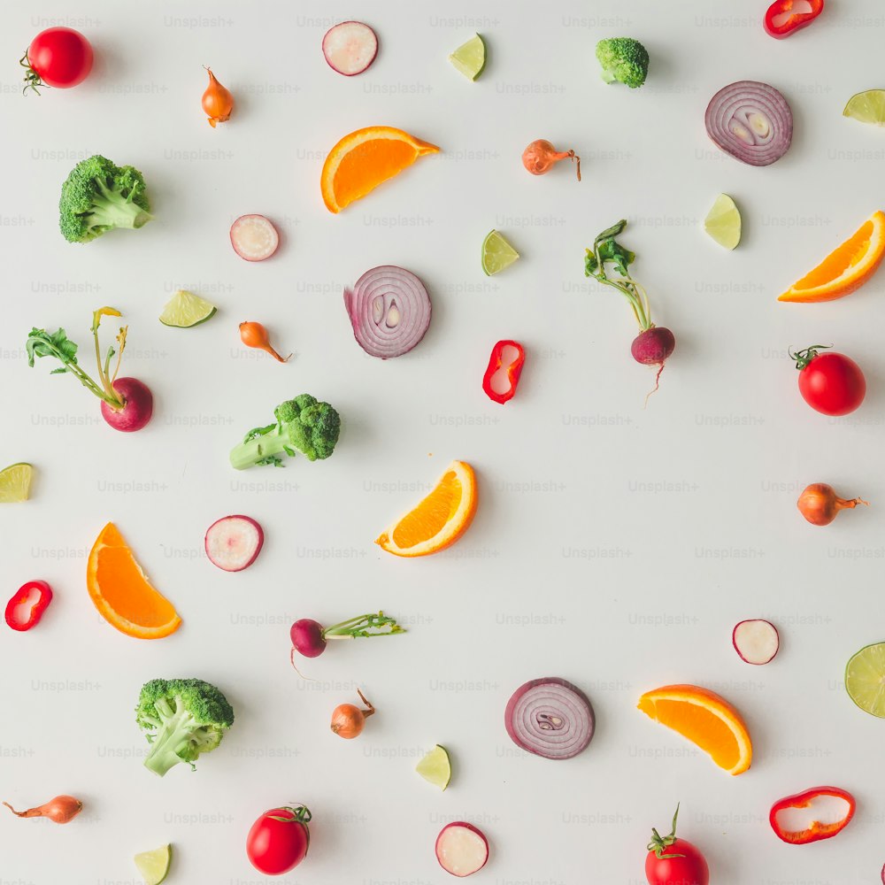 Patrón de comida colorido hecho de brócoli, naranja, pimiento rojo, cebolla, tomates y lima. Plano tendido.