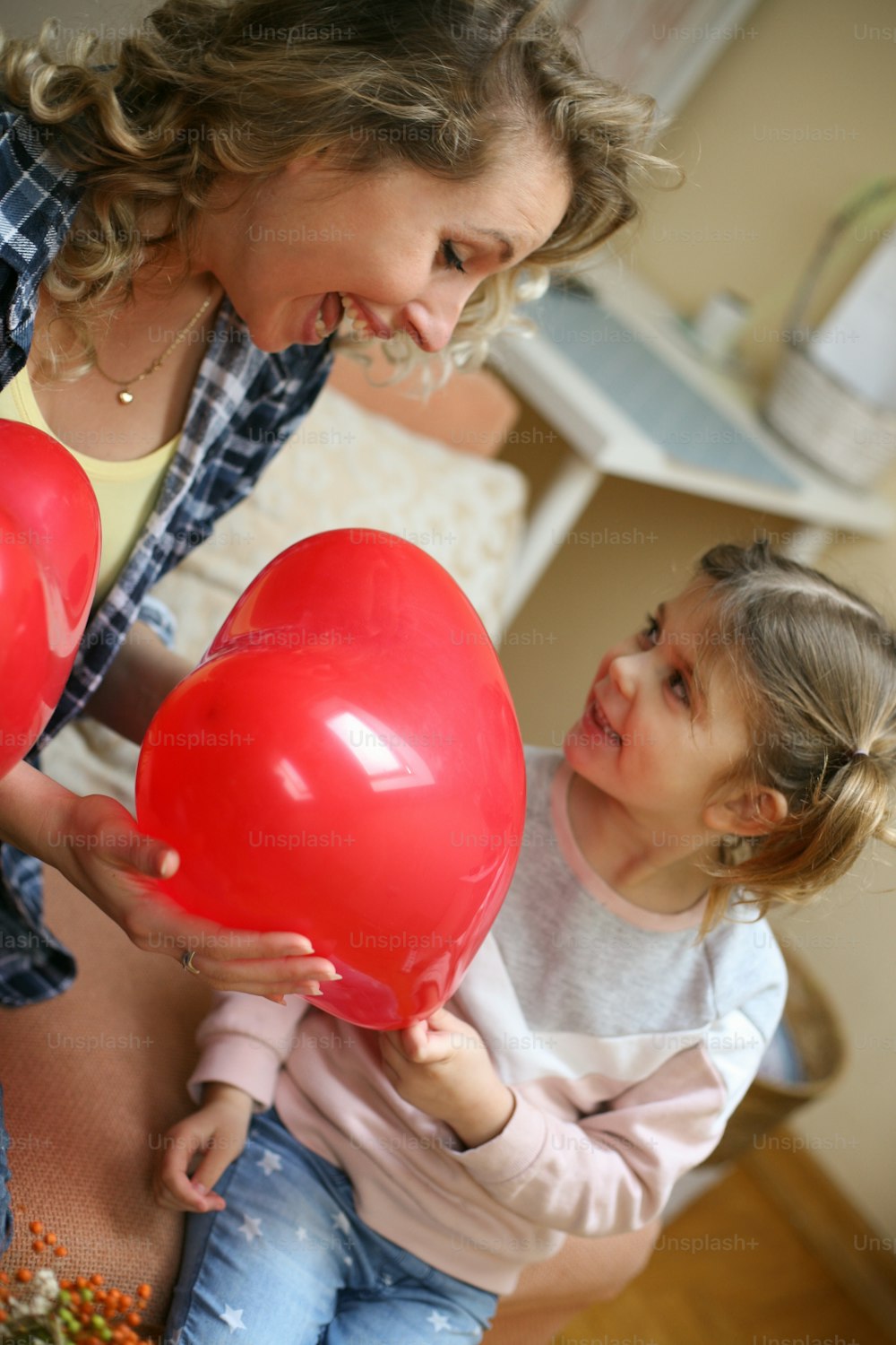 Daughter giving a red balloon to her mother.