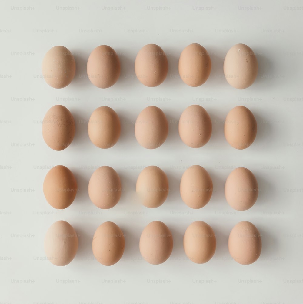 白い背景に卵で作られたクリエイティブなレイアウト。フラットレイ。イースターのコンセプト。