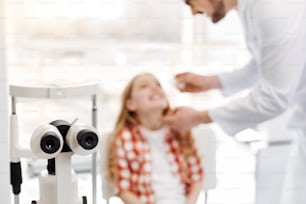 Scrupulous procedure. Handsome friendly skillful doctor being very careful while instilling eyedrops and making sure the medicine working right