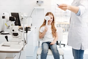 This is B. Charming charismatic young lady covering one of her eyes and naming the latter the doctor pointing at