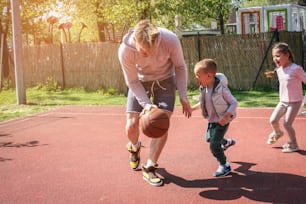 Père célibataire avec ses enfants. Famille caucasienne jouant au basket-ball ensemble. Père célibataire qui passe du temps avec ses enfants.