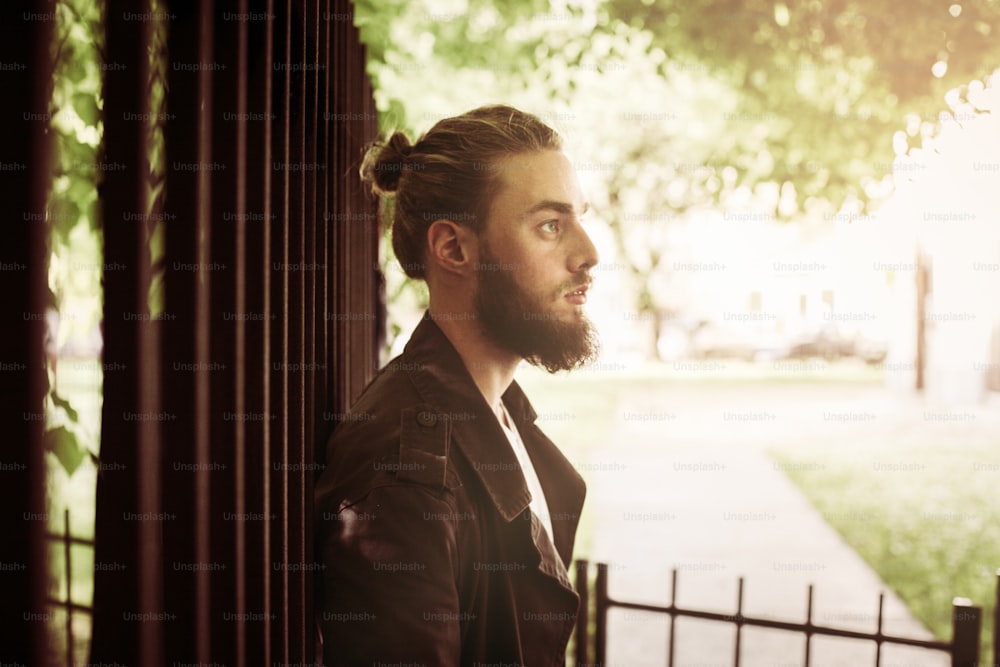 Young man standing in the park and thinking.