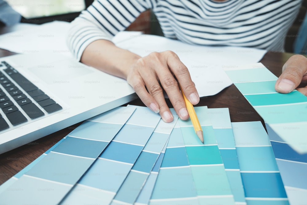 Homme travaillant avec des échantillons de couleur pour la sélection. Graphiste au travail. Échantillons d’échantillons de couleurs.