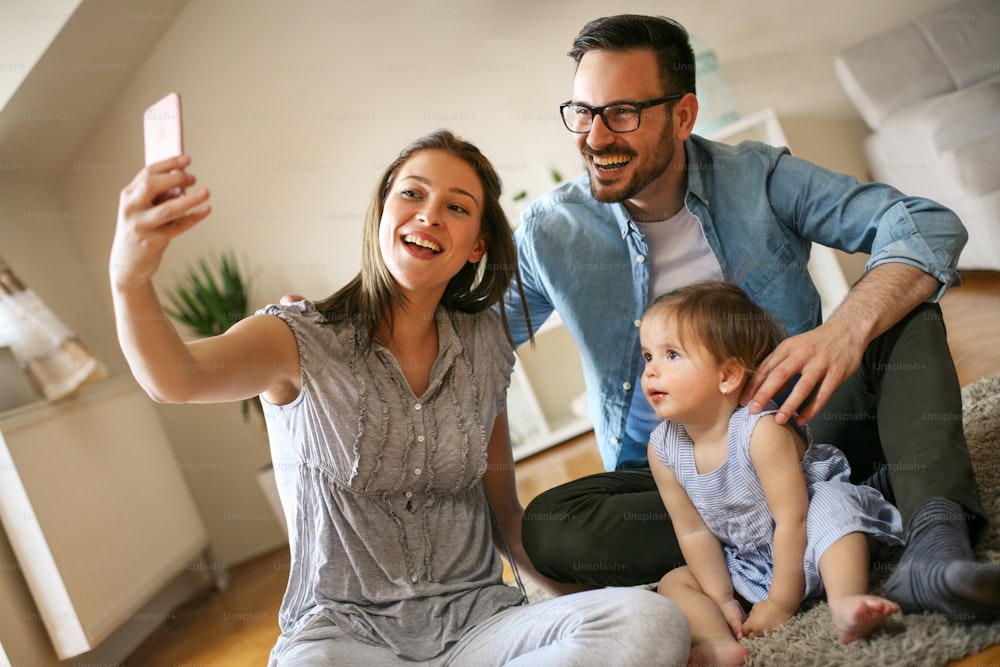 Happy family making self-picture together. Family using smart phone.