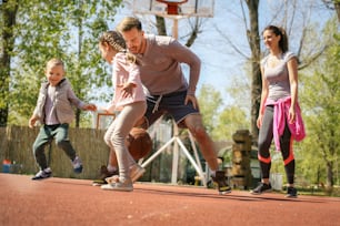 Caucasian family playing basketball together