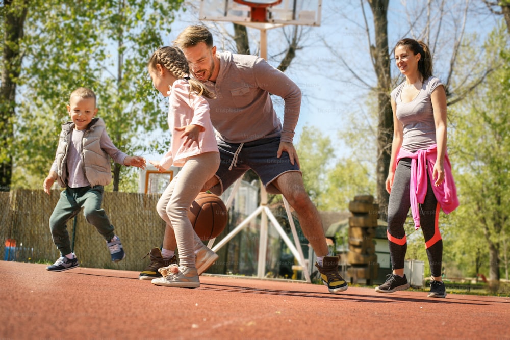 Caucasian family playing basketball together