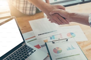 Businessman and partner shaking hands in office