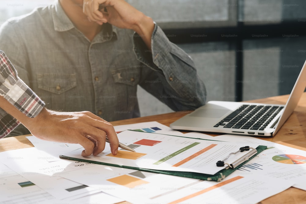 Business team hands at work with financial reports and a laptop computer in office