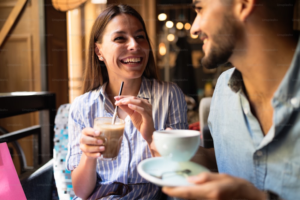 Young attractive cheerful couple on date in coffee shop