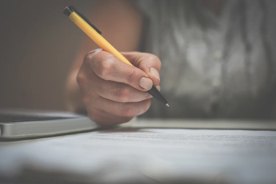 Close-up of a hand signing a document