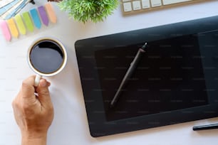 Diseñador gráfico que utiliza una tableta gráfica para hacer su trabajo en el escritorio