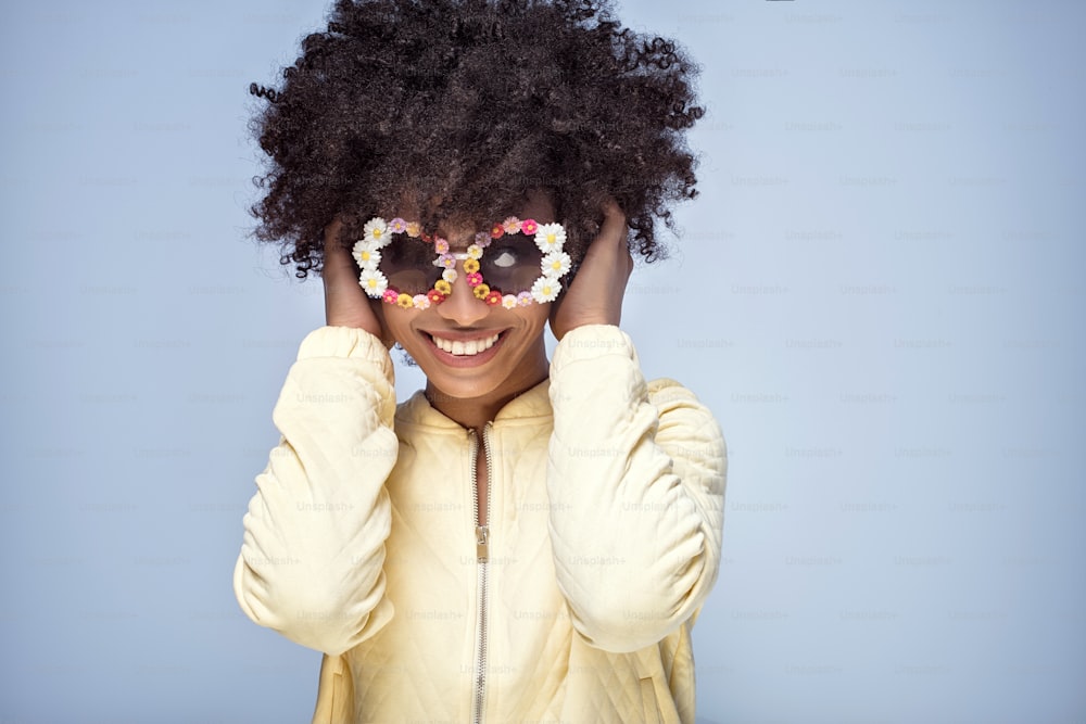Portrait of happy young african american girl with afro hairstyle and funny sunglasses.