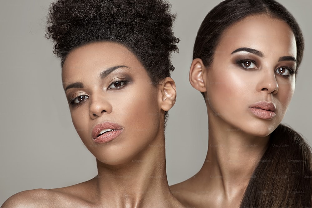 Dos jóvenes mujeres afroamericanas de belleza. Retrato de primer plano de hermosas chicas con maquillaje natural.