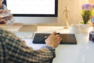 Graphic designer using digital tablet and modern desktop computer.