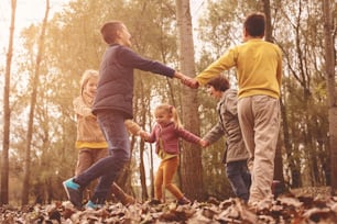 Grupo de cinco personas divirtiéndose en el parque de otoño.