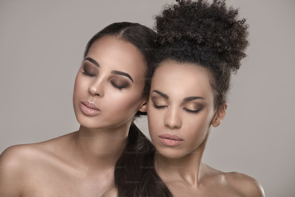 두 명의 아름다운 젊은 아프리카 계 미국인 여성. 자연스러운 화장을 한 아름다운 소녀들의 초상화를 근접 촬영.