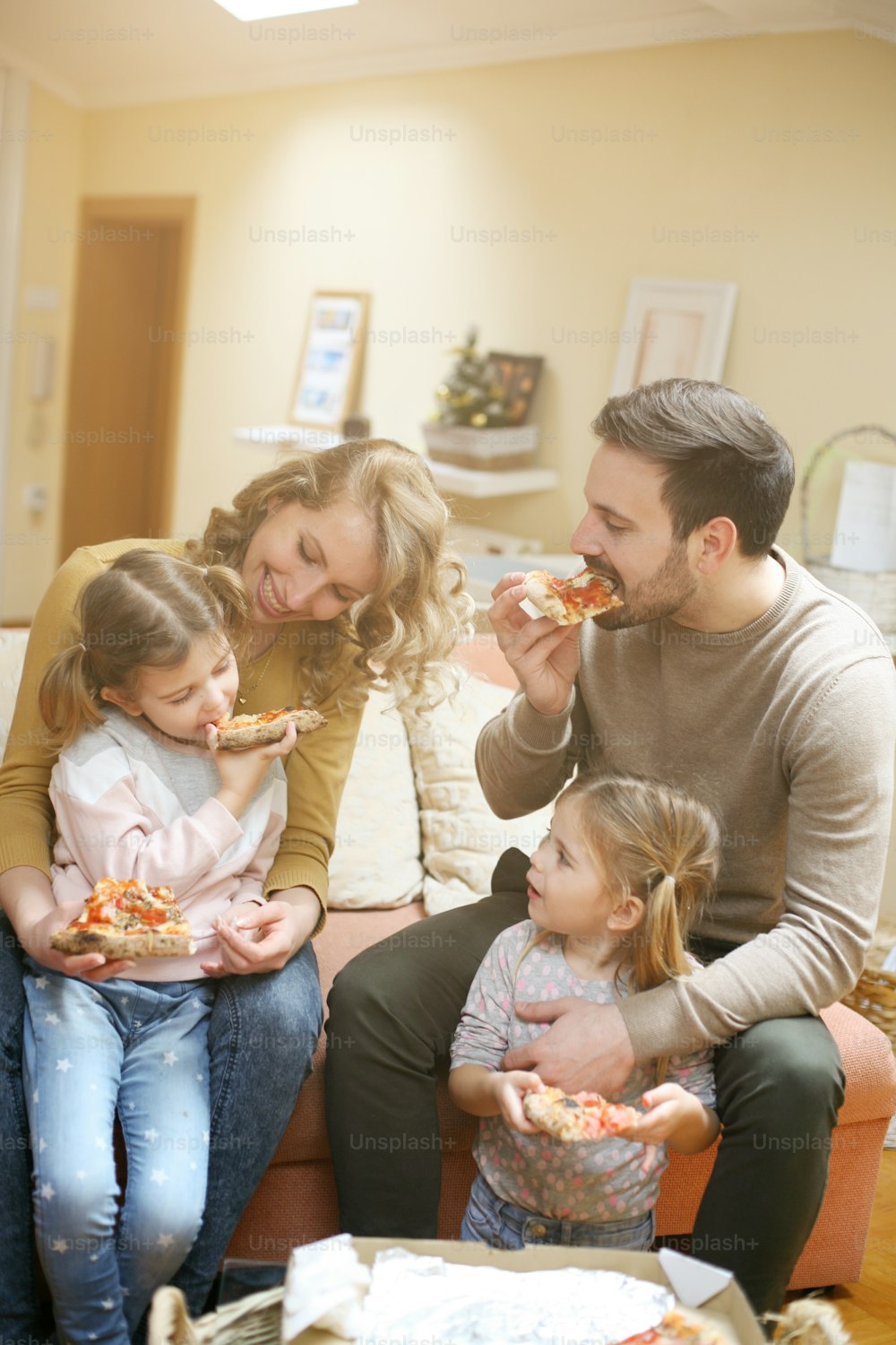 親子で一緒にピザを食べる。家で一緒に食事を楽しむ幸せな家族。