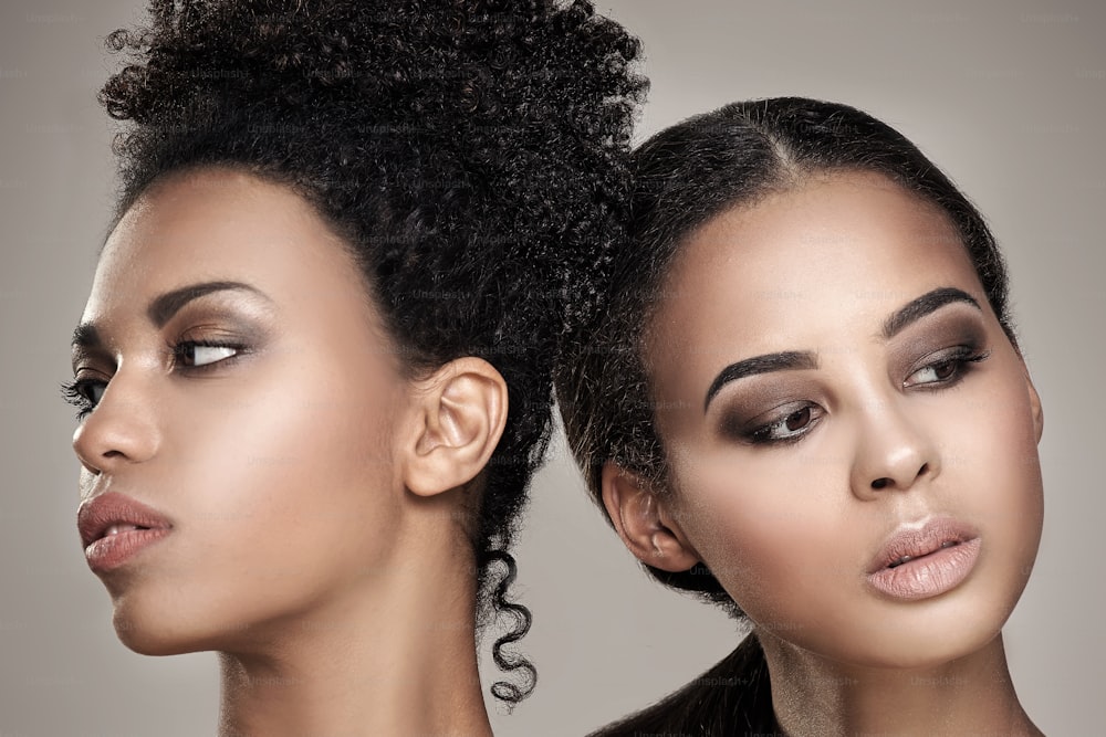 Duas mulheres afro-americanas jovens beleza. Retrato em close-up de meninas bonitas com maquiagem natural.