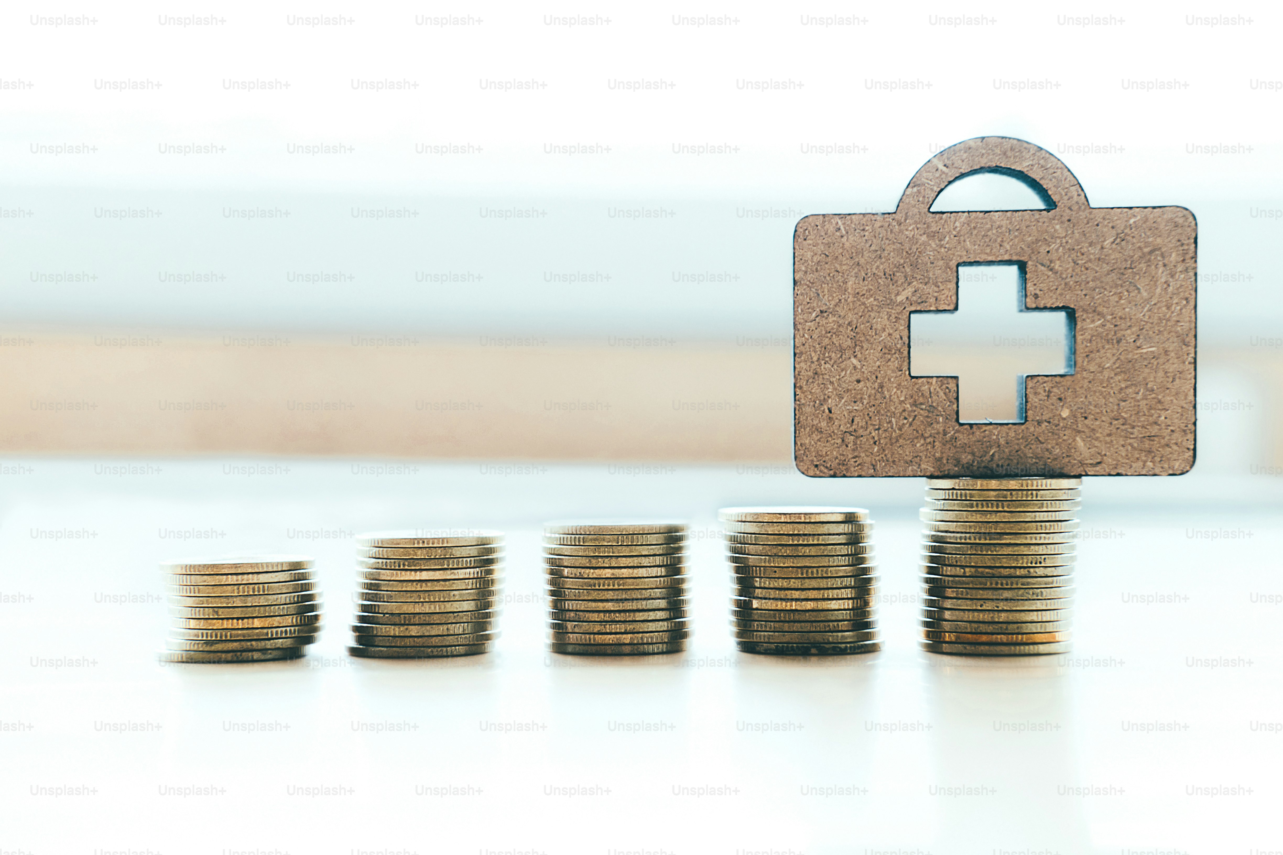 Health insurance copyspace background idea concept. Coin stacks and medical bag wood