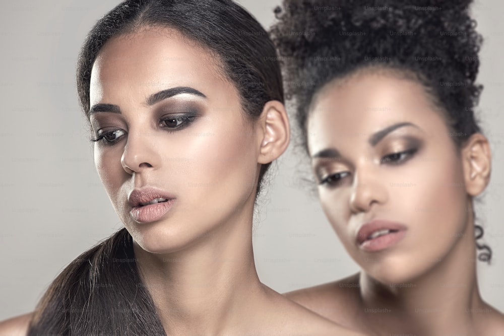 Duas mulheres afro-americanas jovens beleza. Retrato em close-up de meninas bonitas com maquiagem natural.