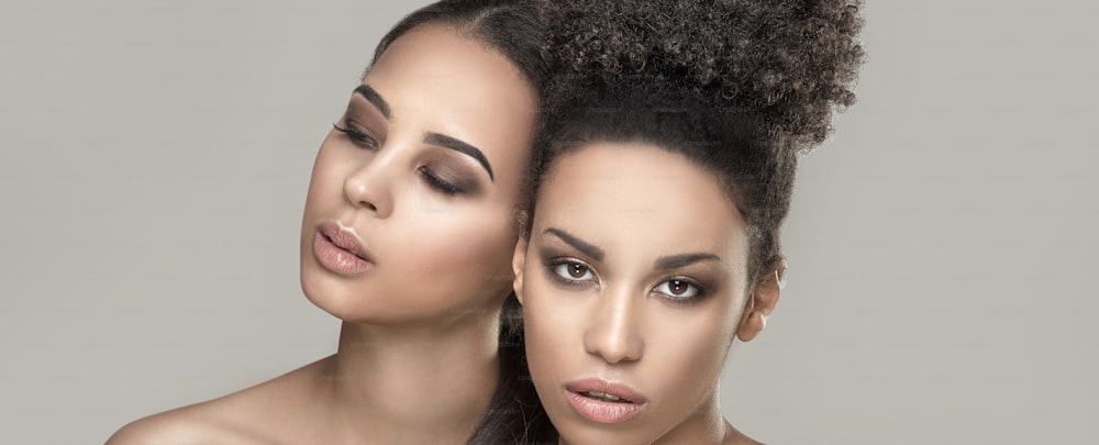 Dos jóvenes mujeres afroamericanas de belleza. Retrato de primer plano de hermosas chicas con maquillaje natural.