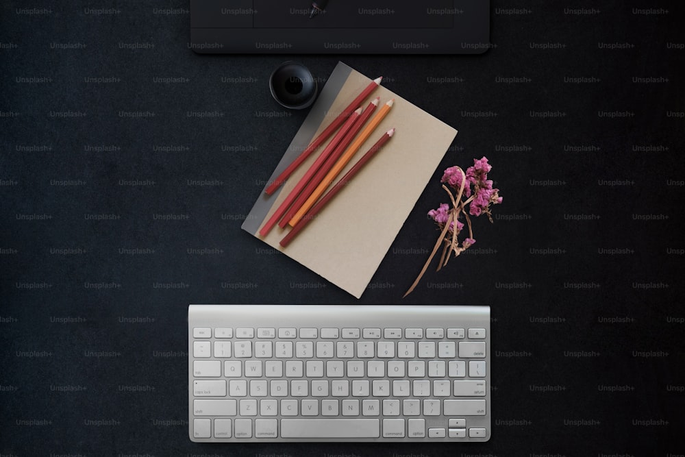 Concepto de espacio de trabajo mínimo. Cosas creativas, computadora y tableta gráfica digital en una mesa de escritorio de oficina de superficie oscura moderna.
