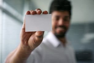 African man holding a blank business card. Focus on blank card. Space for copy.