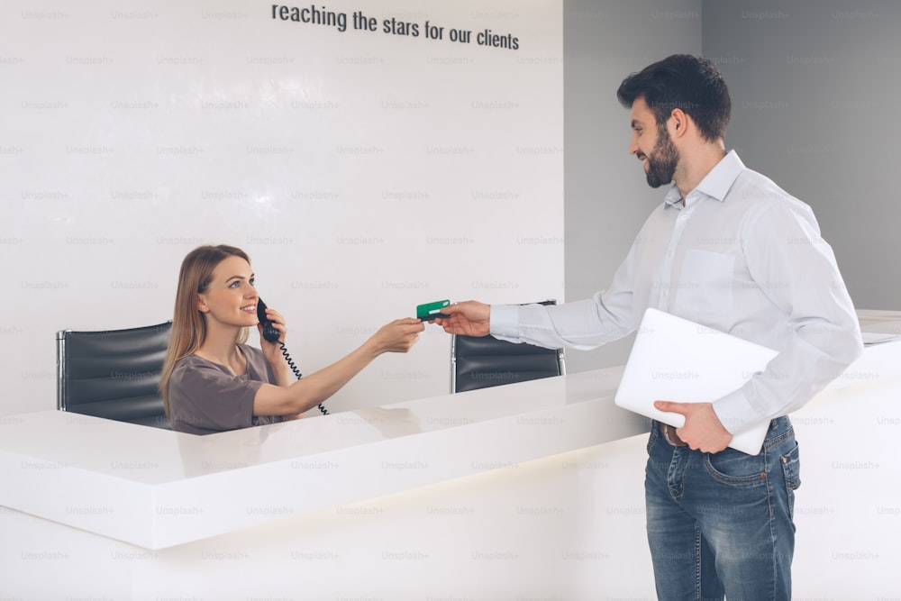 Young female and male in the company office credit card payment